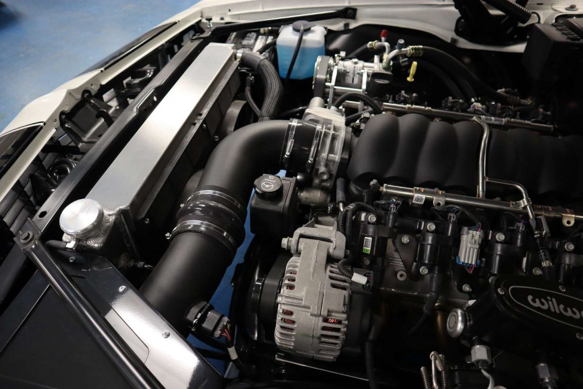 A car engine with the hood open and the engine bay.